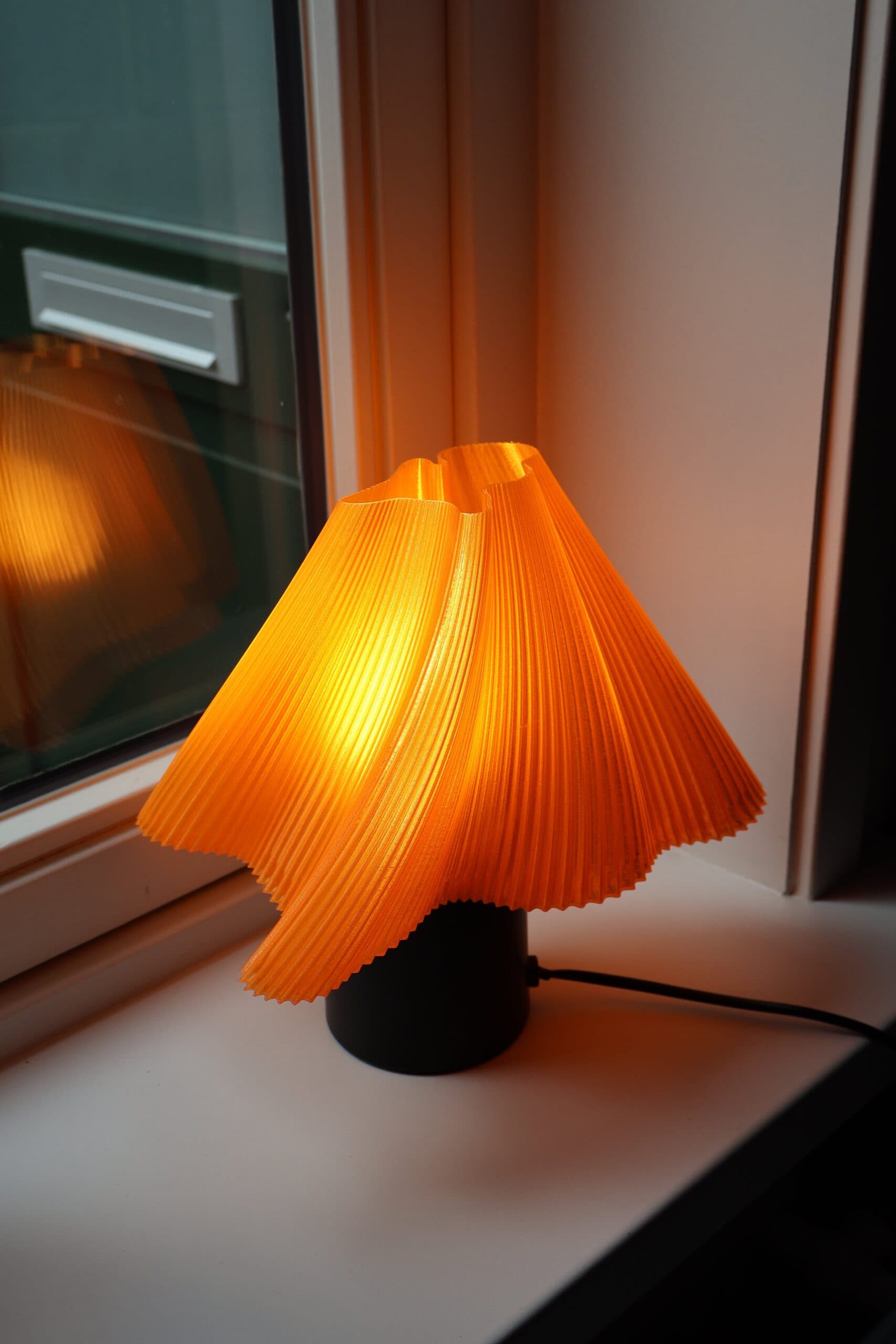 Oranje tafellamp met 3D-geprinte kap met de LED-lamp aan